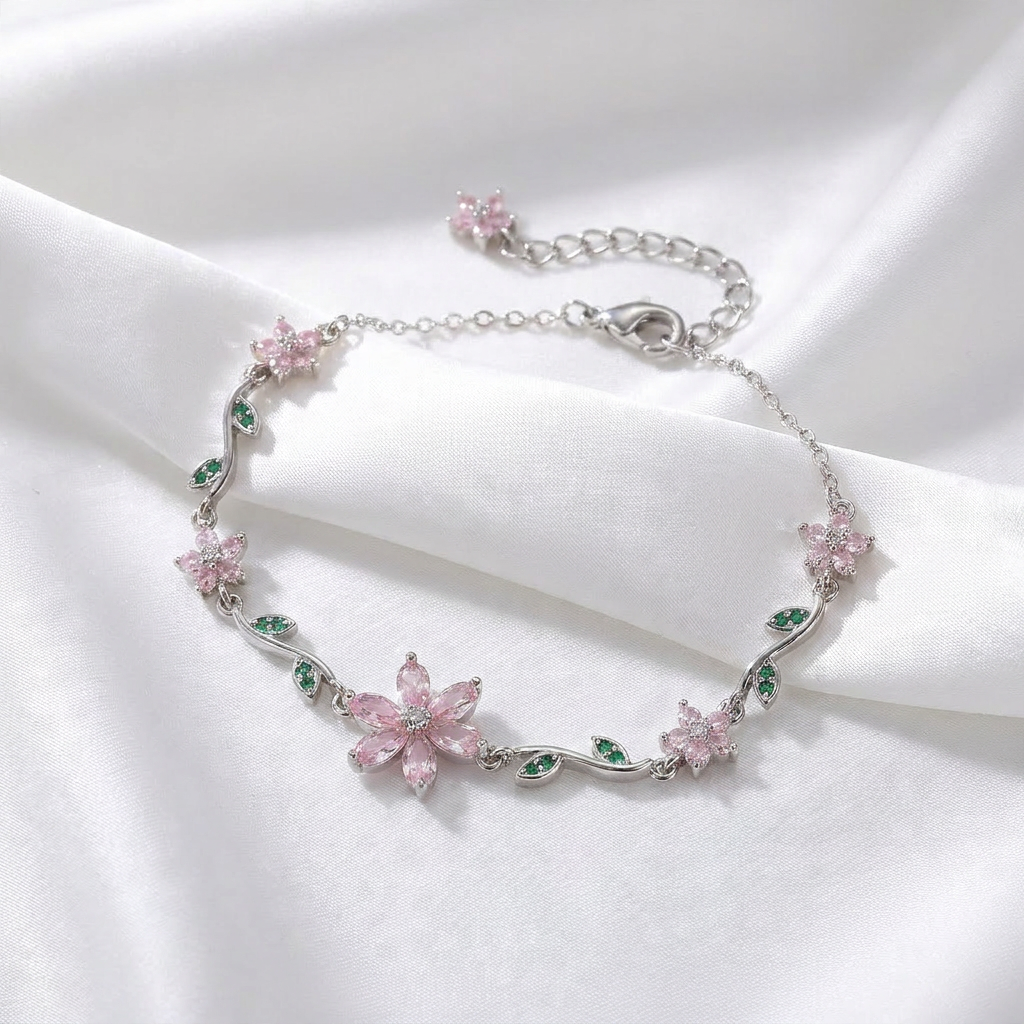Silver bracelet with pink floral charms on a white fabric background
